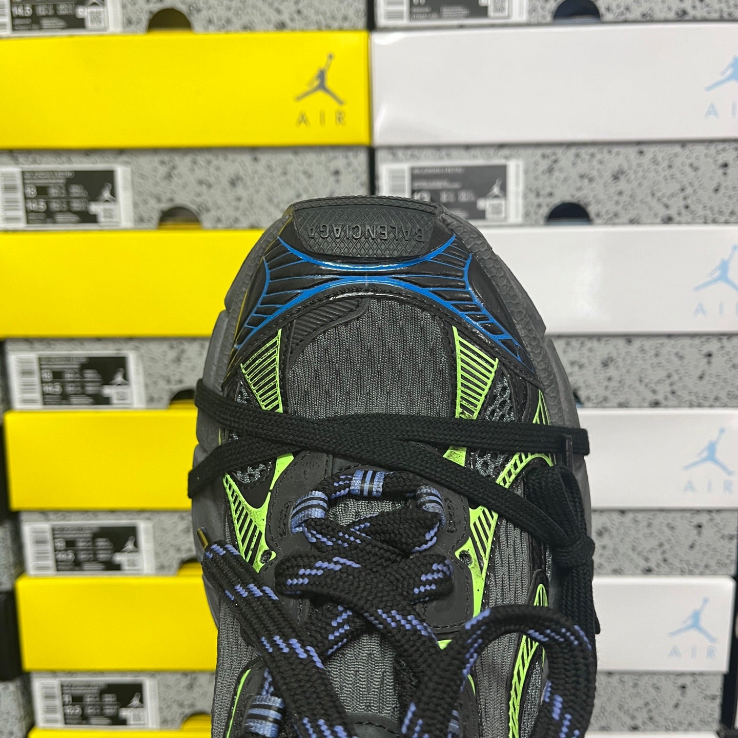 Black toe cap of Balenciaga sneaker with neon green panel and blue lace detail