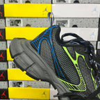 Balenciaga running sneaker with black mesh upper, neon green accents, and blue heel tab