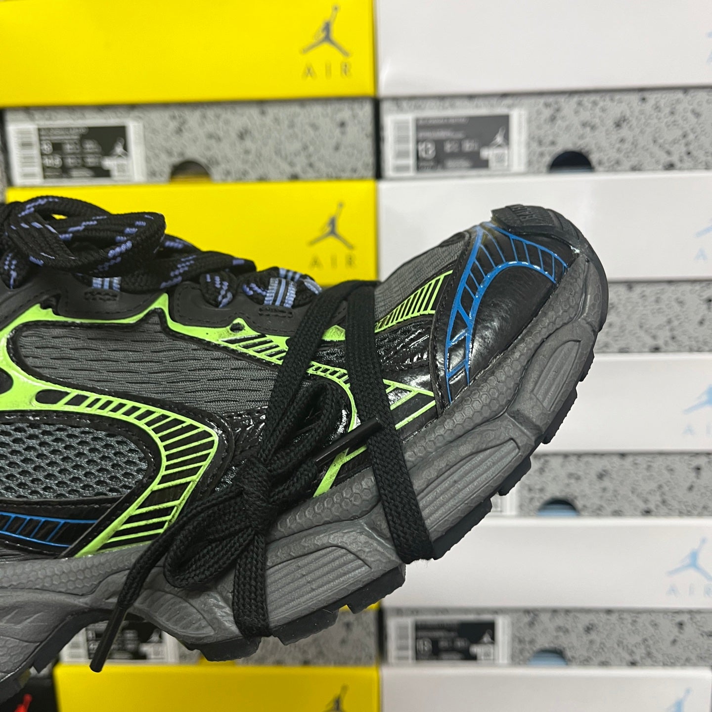 Balenciaga sneaker side view with neon green stripe, blue trim, and chunky gray sole