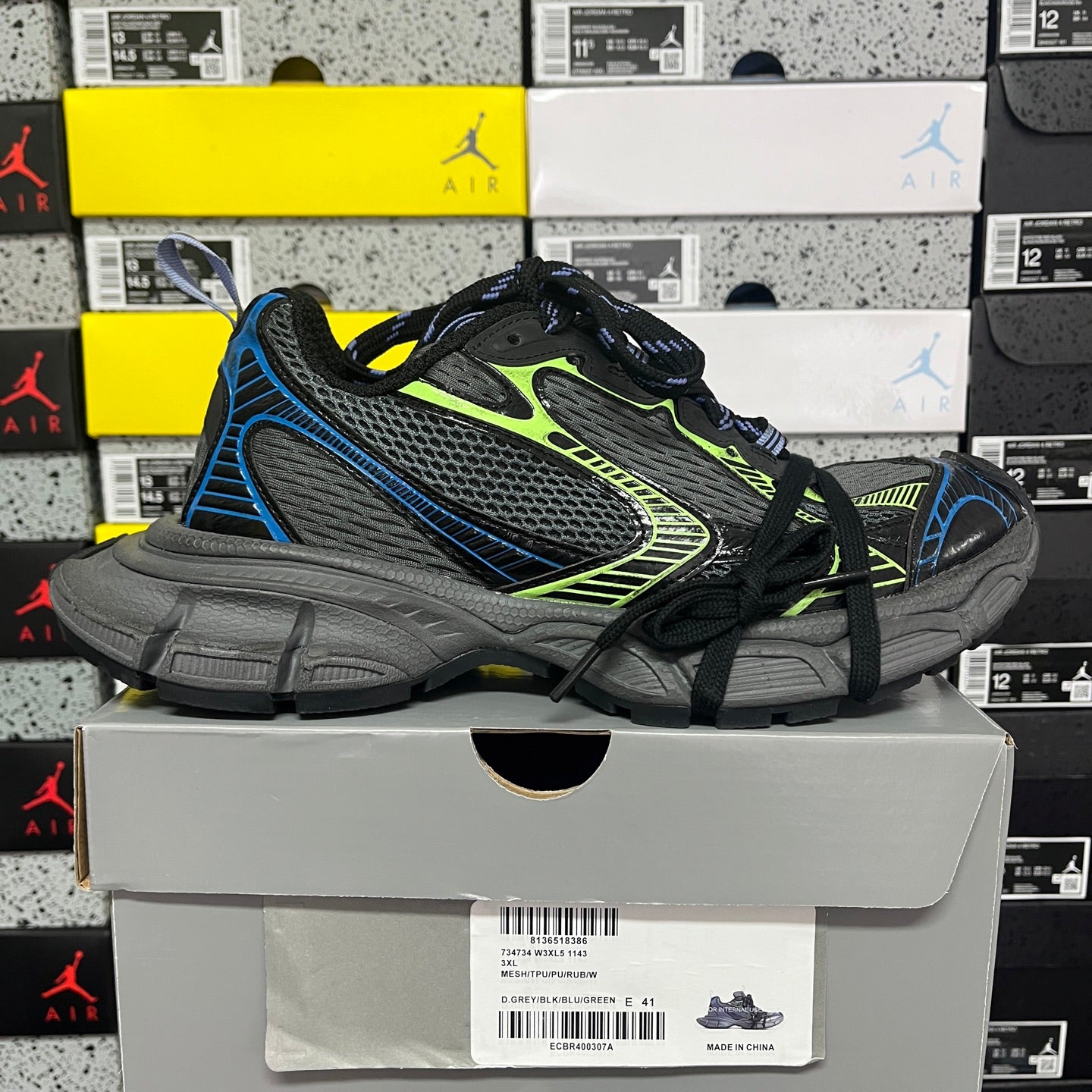 Black Balenciaga sneakers with mesh panels, neon green lines, and blue edging