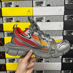 Three-quarter view of chunky sneakers in gray with red, orange, and white details