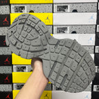 Gray rubber outsole with tread pattern, held in hand