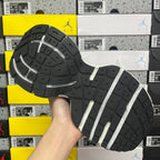 Grey running sneaker outsole with traction tread and white stripe detail
