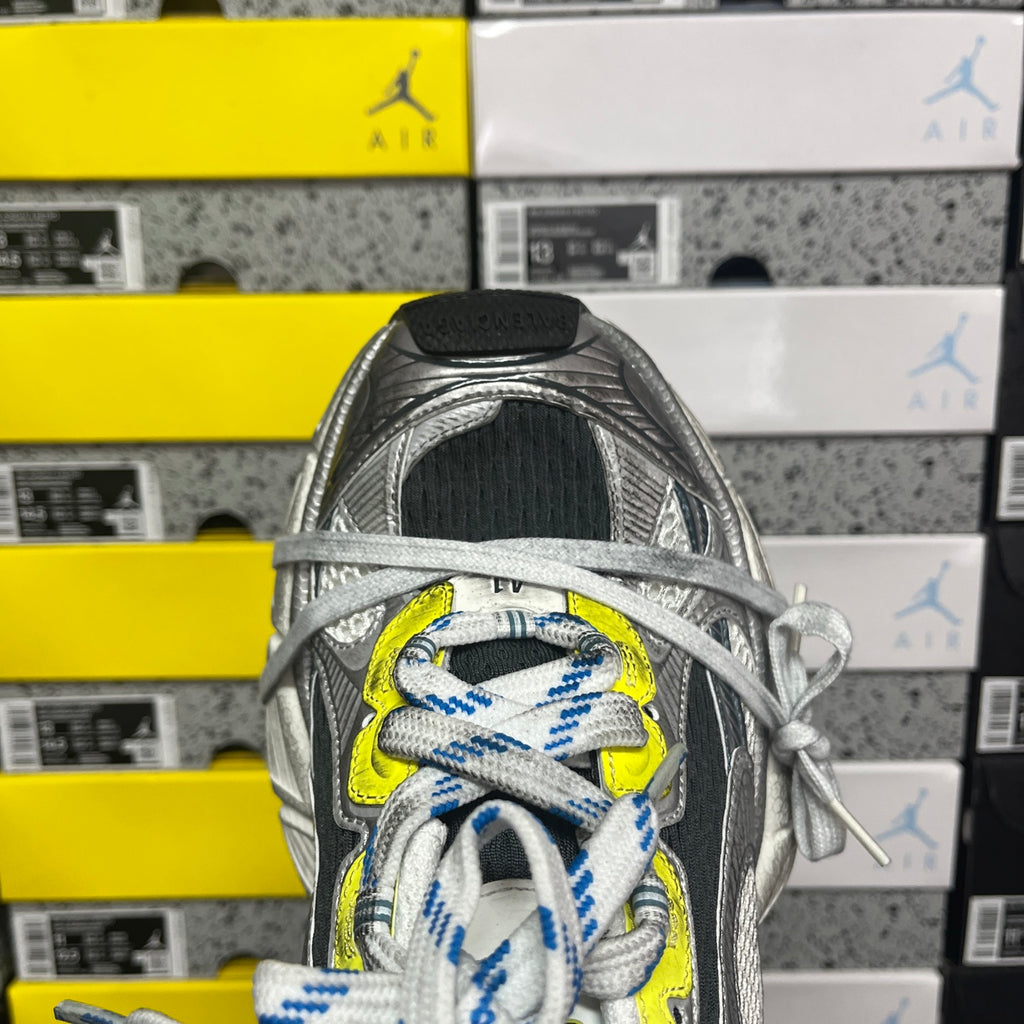 Grey mesh sneaker with neon yellow eyelet and blue striped laces, open collar view