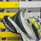 Grey running sneaker with dark side panel and neon yellow accent, blue striped laces