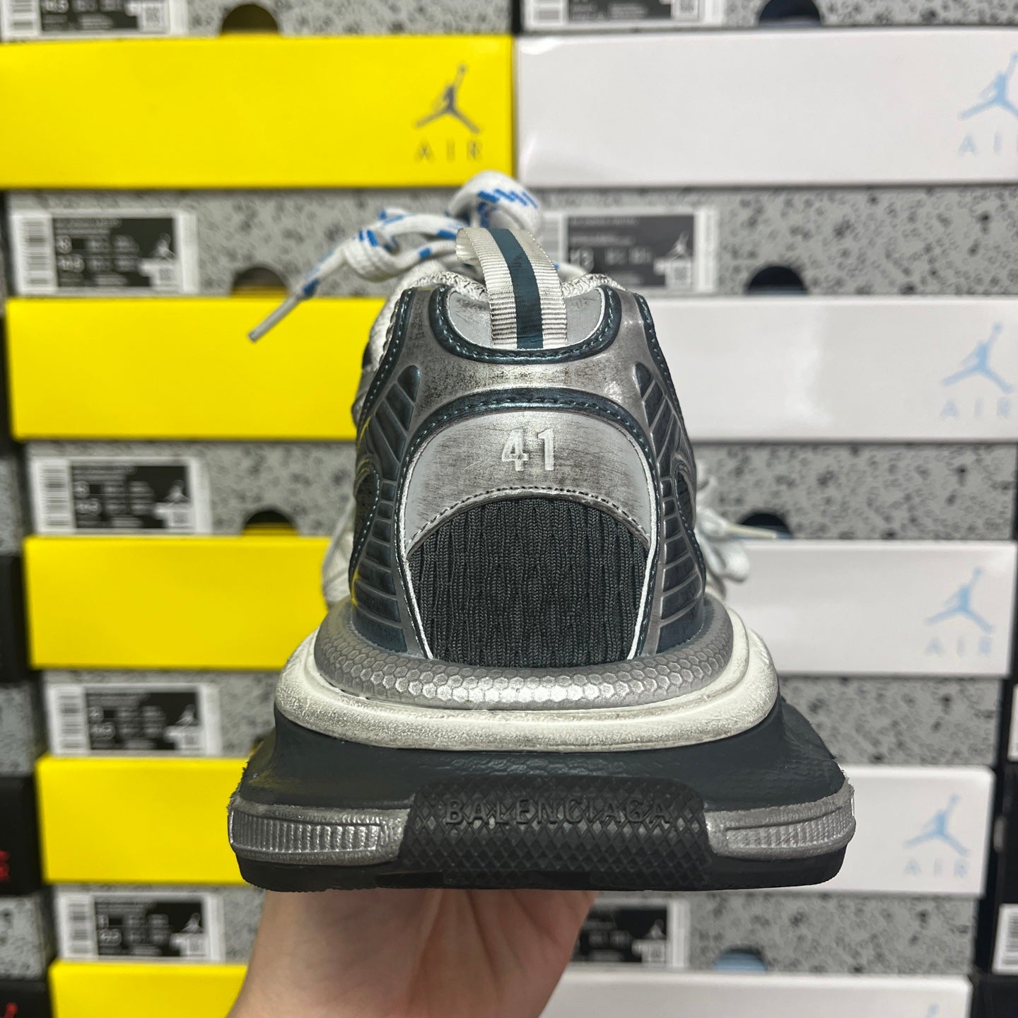 Grey running sneaker heel with '41' mark, black midsole and white laces