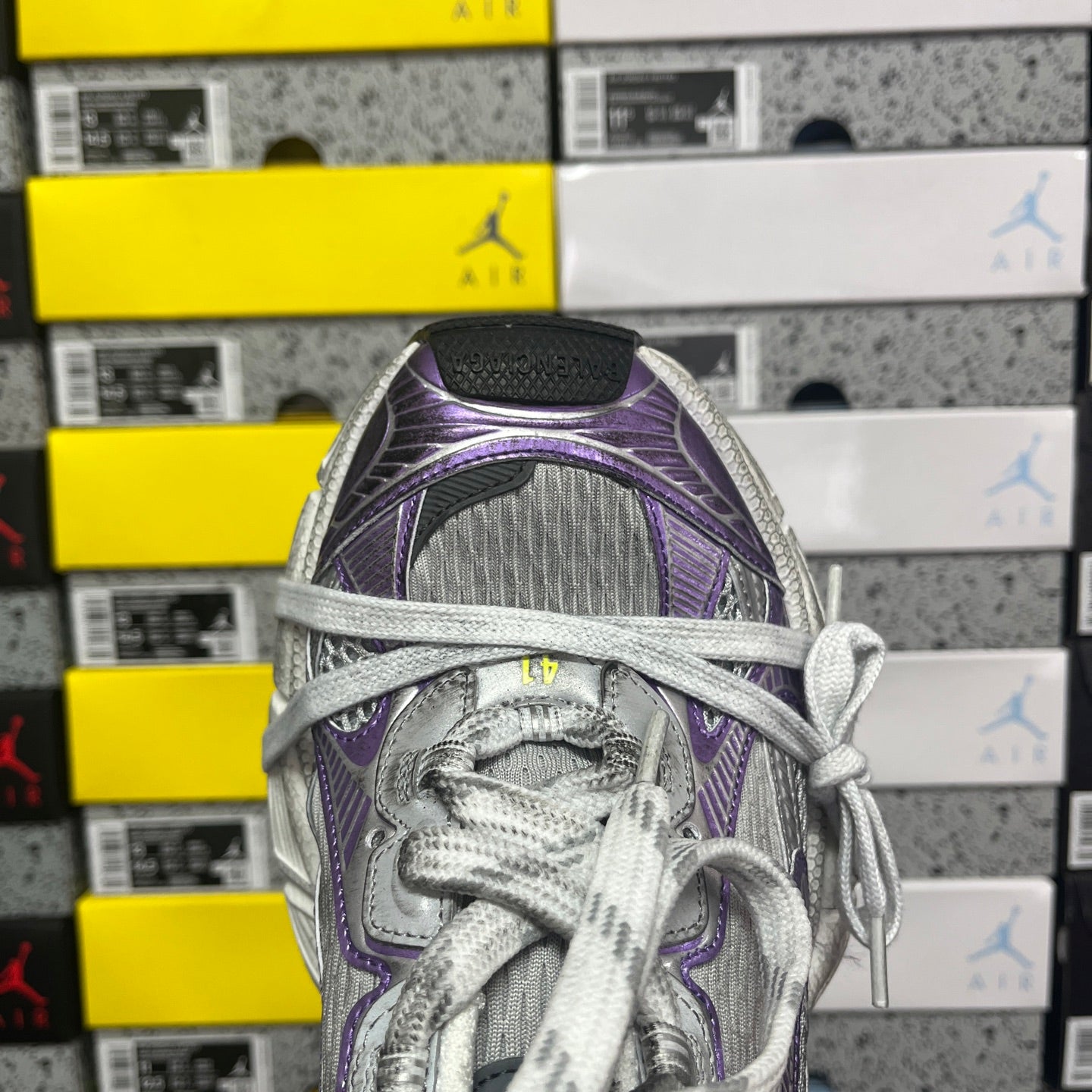 Unisex running shoe close-up, purple and silver mesh tongue with gray lace-up