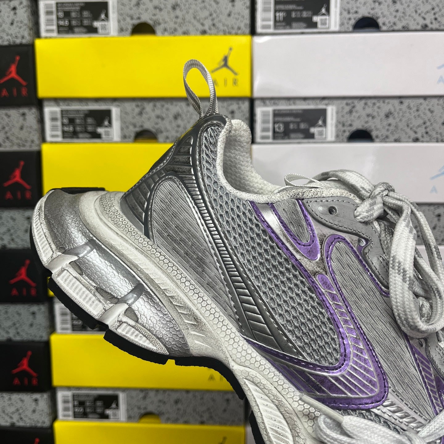 Unisex running shoe heel and midsole view, metallic silver with purple accents