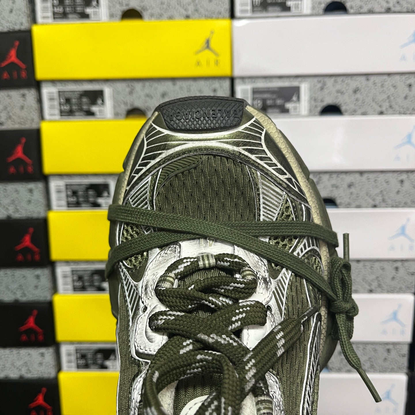 Green and silver sneaker upper detail with lace-up front and patterned overlays