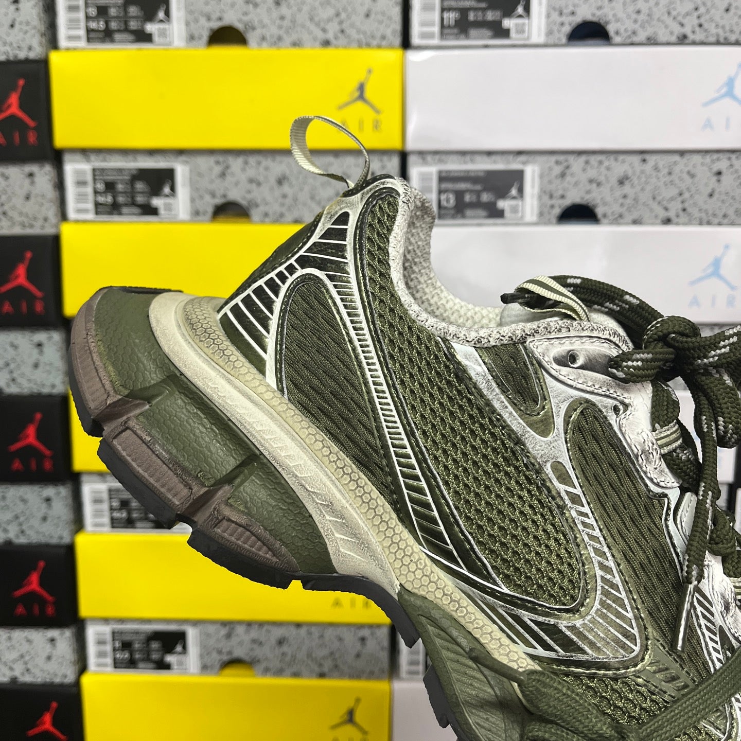 Green and silver sneaker, three-quarter angle with lace-up closure and rounded toe
