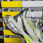 Silver and lime green athletic sneaker, black heel trim, white laces, side profile.