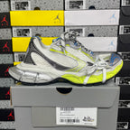 Silver and lime green athletic sneaker with white laces, resting on a box, angled side.