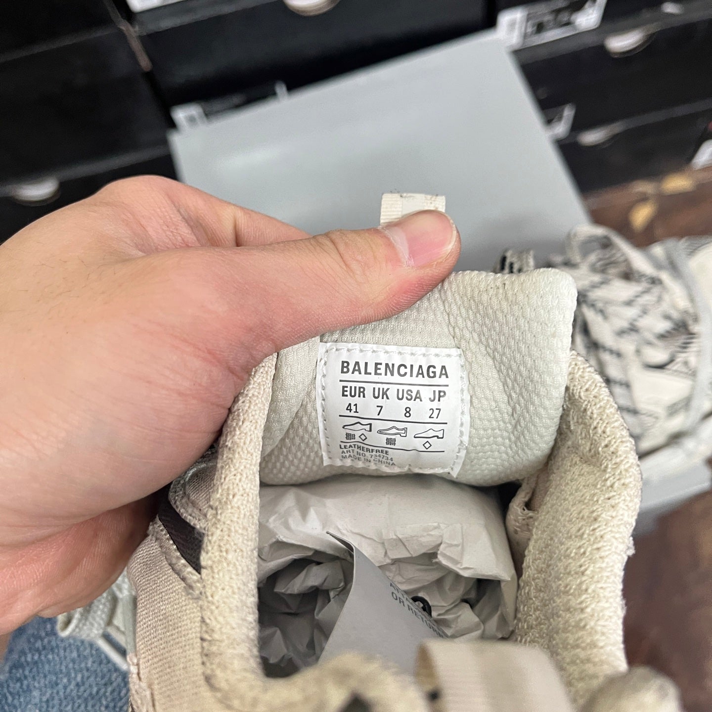 Light gray sneaker tongue label with size info and care text