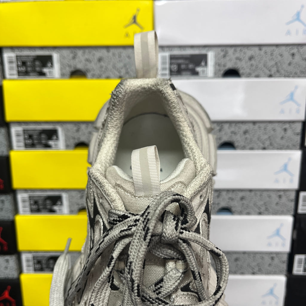 Light gray sneaker showing padded inner collar and lace-up opening, close-up