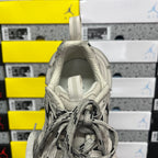 Light gray sneaker showing padded inner collar and lace-up opening, close-up