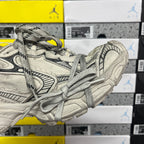 Light gray sneaker with black outline details, padded collar, and lace-up front