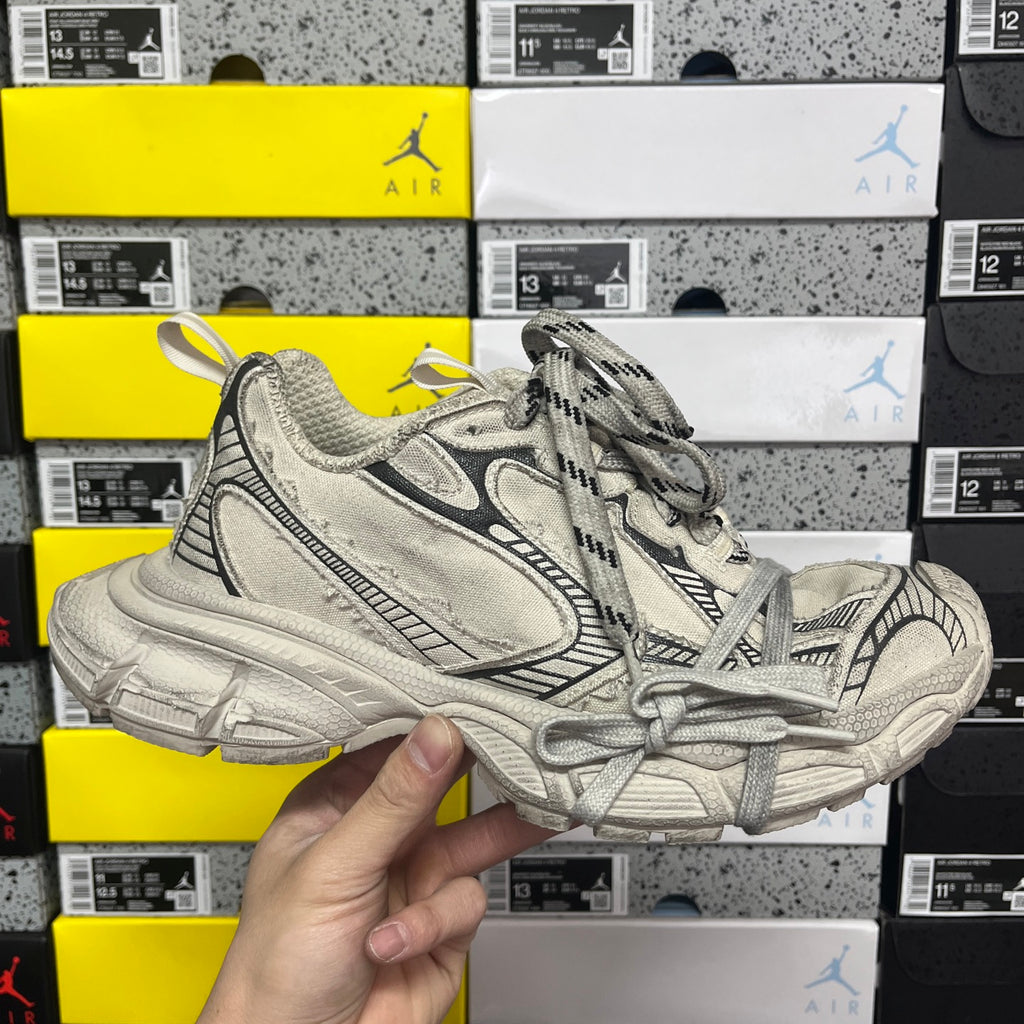 Light gray Balenciaga sneaker with black paneling, lace-up closure, chunky rubber sole