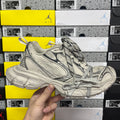 Light gray Balenciaga sneaker with black paneling, lace-up closure, chunky rubber sole