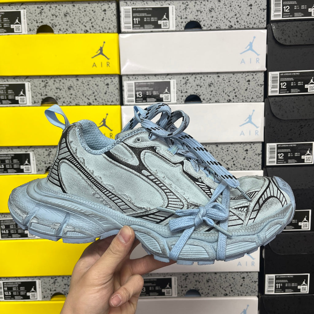 Light blue Balenciaga-style lace-up sneakers with textured panels and chunky sole