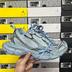 Light blue Balenciaga-style lace-up sneakers with textured panels and chunky sole