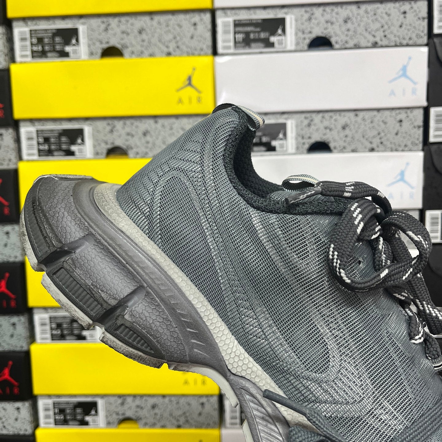 Gray lace-up running shoe with textured knit upper and white side accent