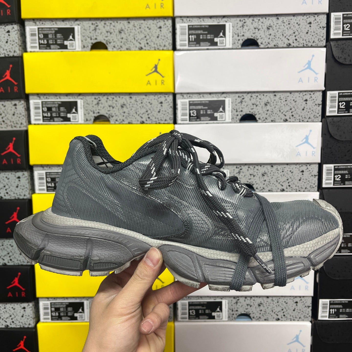 Gray lace-up athletic shoe with black laces and chunky sole profile