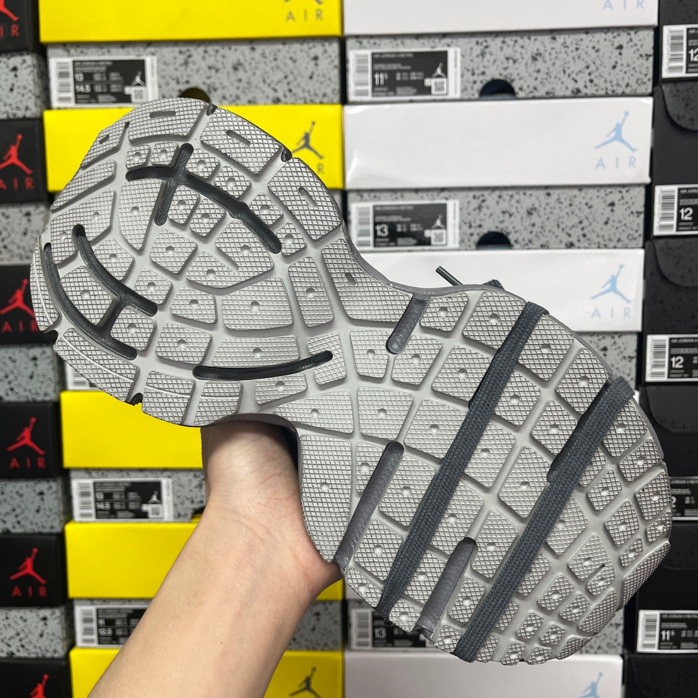 Gray athletic sneaker outsole with deep tread and dark strap detail