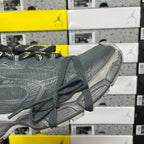 Gray athletic sneaker with laced upper, textured fabric, and chunky sole