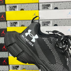 Black lace-up knit sneaker with Balenciaga text logo and Under Armour emblem on side