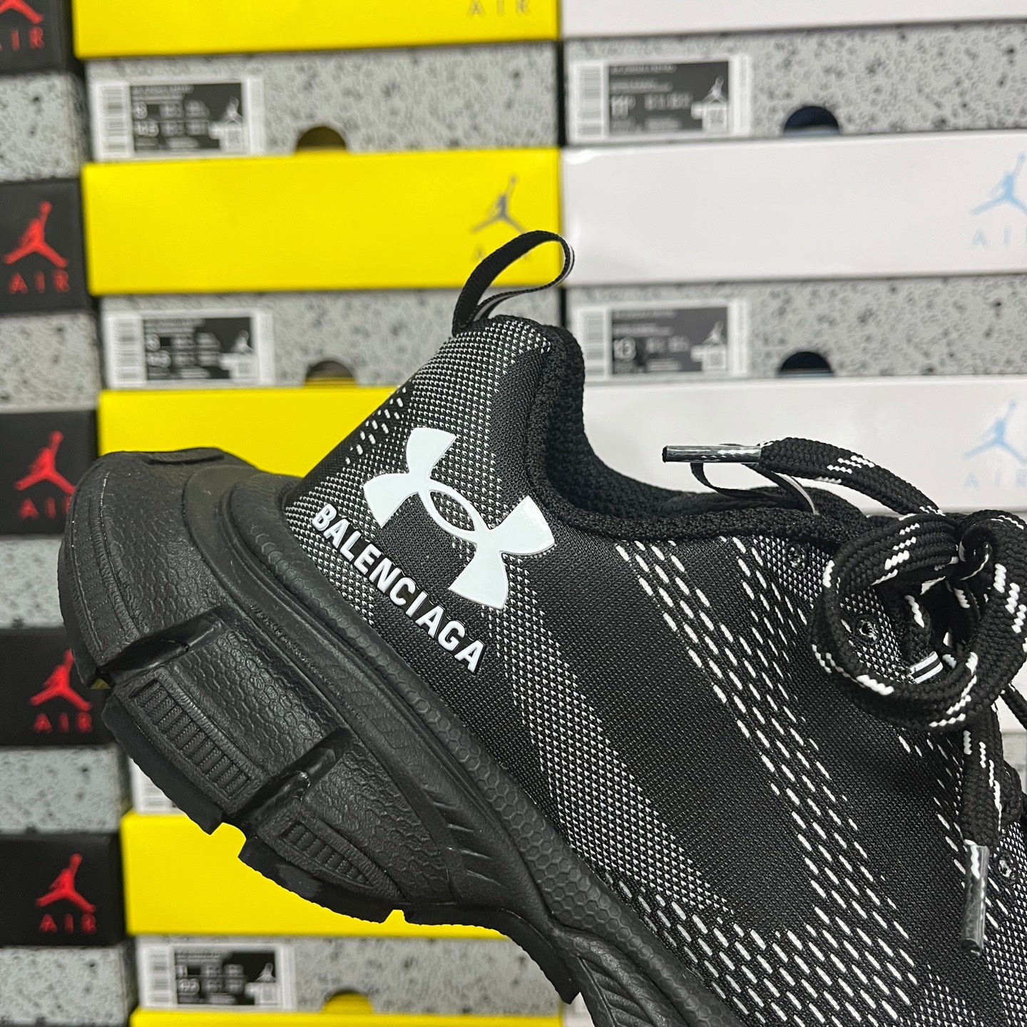 Black lace-up knit sneaker with Balenciaga text logo and Under Armour emblem on side