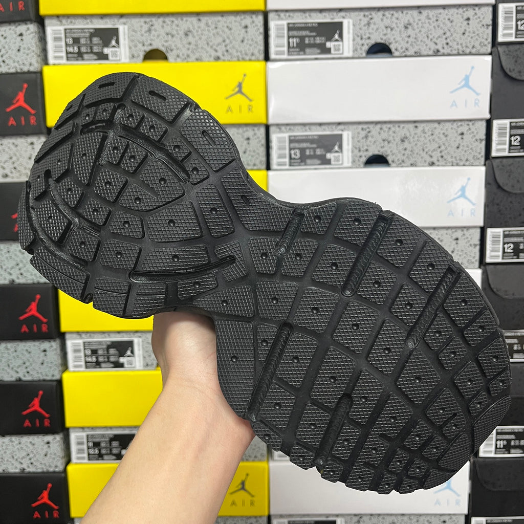 Black outsole of lace-up sneaker with grid tread pattern and raised traction lugs