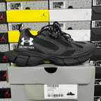 Black lace-up knit sneakers with thick sole, Under Armour logo, and Balenciaga branding