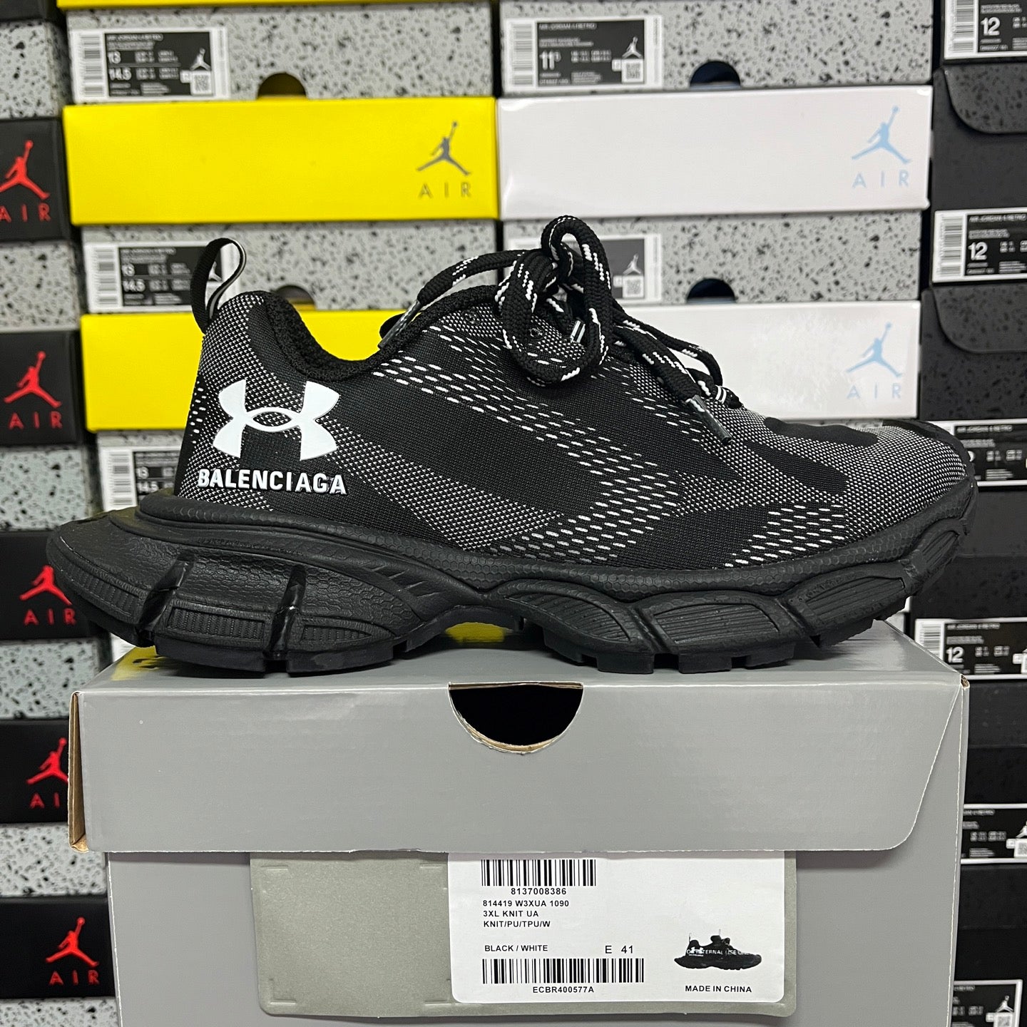 Black lace-up knit sneakers with thick sole, Under Armour logo, and Balenciaga branding