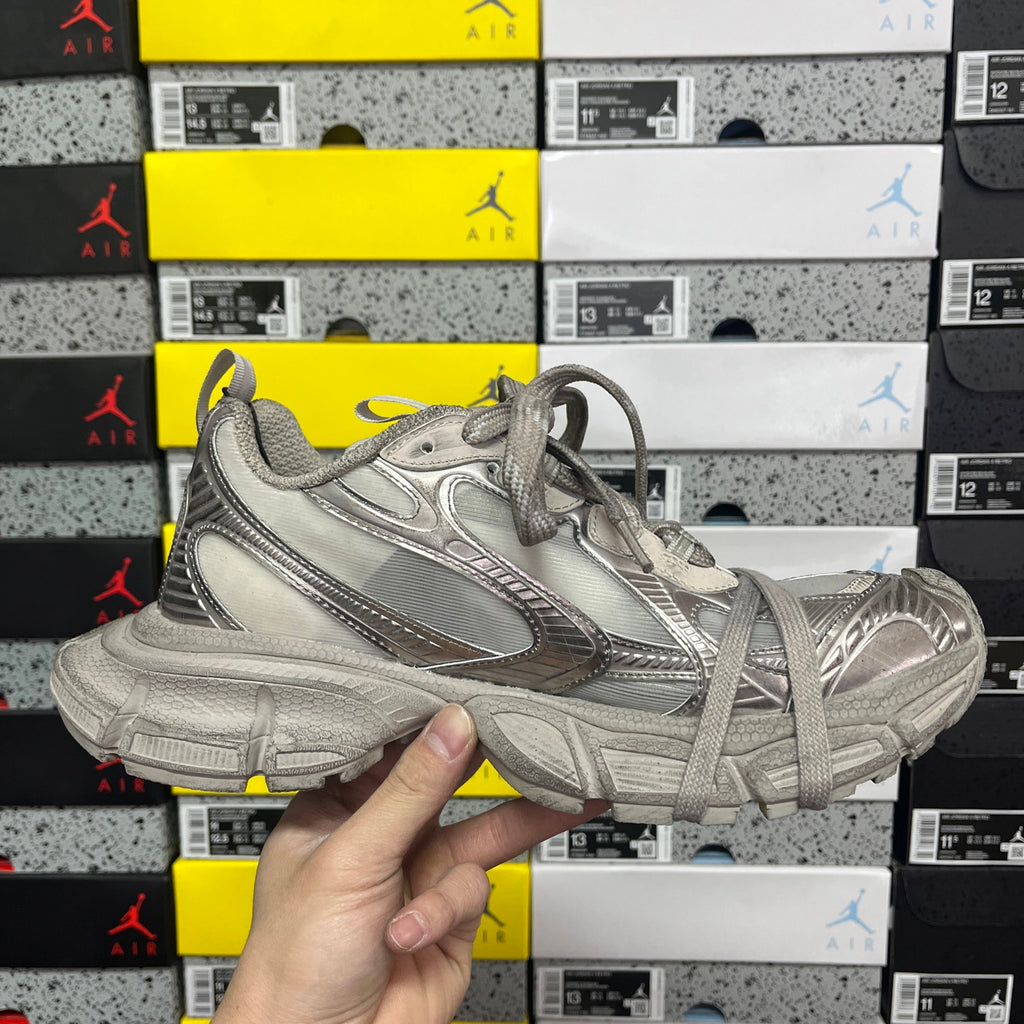 Balenciaga unisex gray sneaker front quarter view with lace-up and logo detailing.