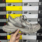 Balenciaga unisex gray sneaker front quarter view with lace-up and logo detailing.