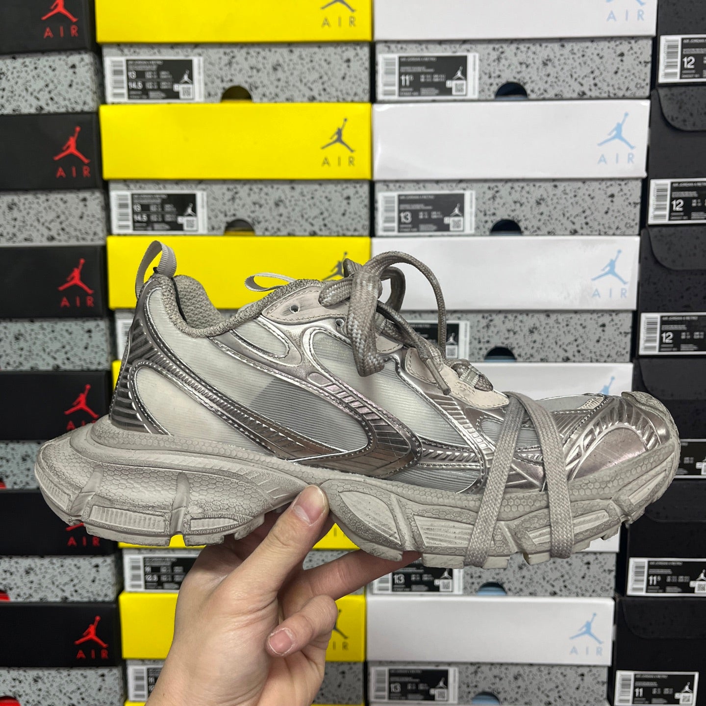 Balenciaga unisex gray sneaker front quarter view with lace-up and logo detailing.