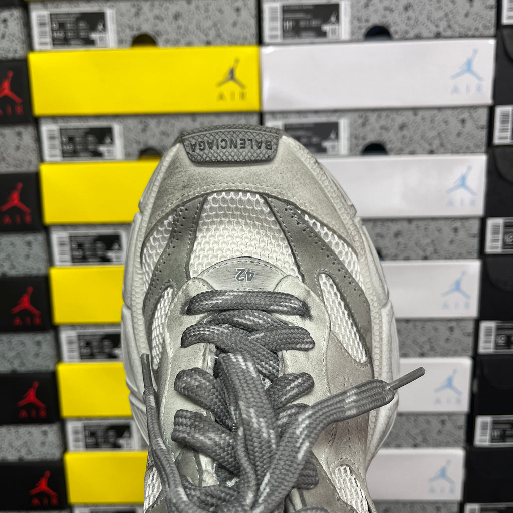 Balenciaga sneaker front view with gray laces and perforated toe panel on light gray upper