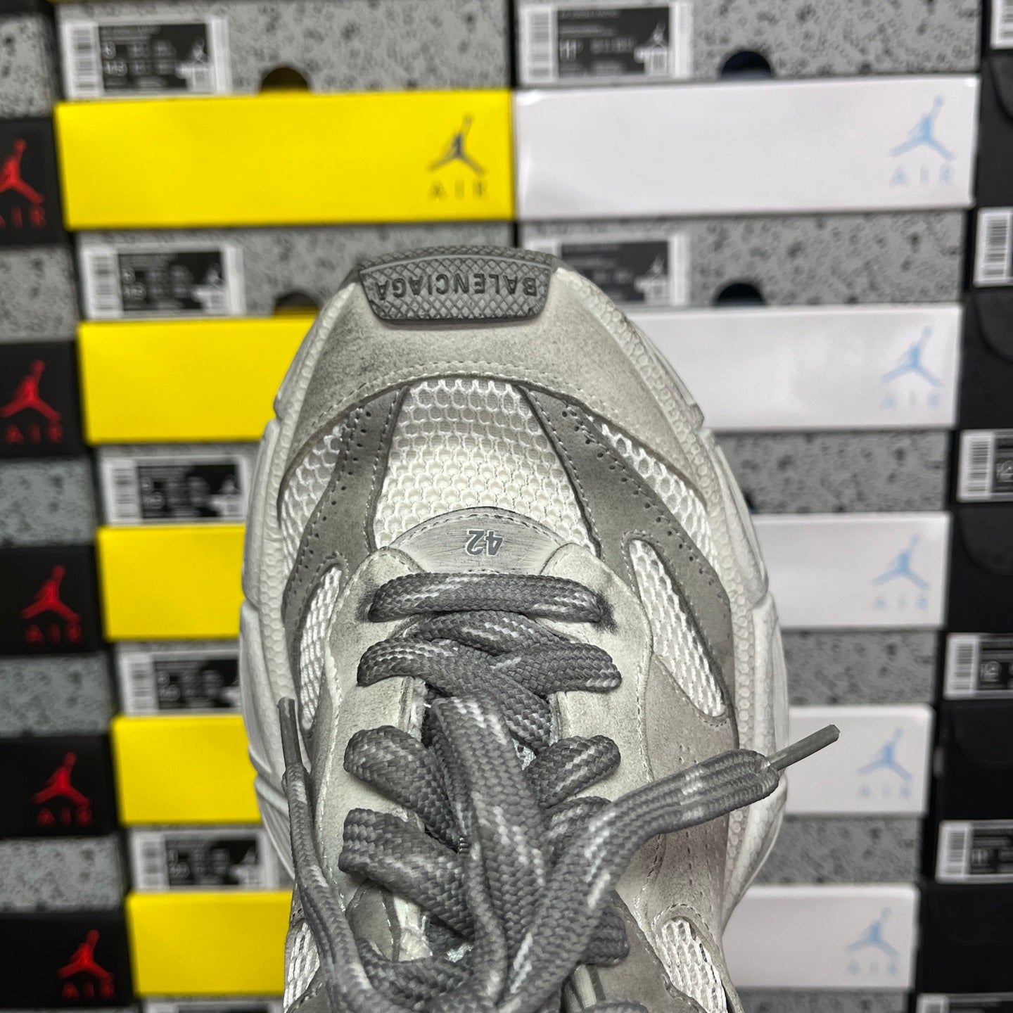 Balenciaga sneaker front view with gray laces and perforated toe panel on light gray upper