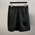 Black satin shorts with elastic waistband and straight hem
