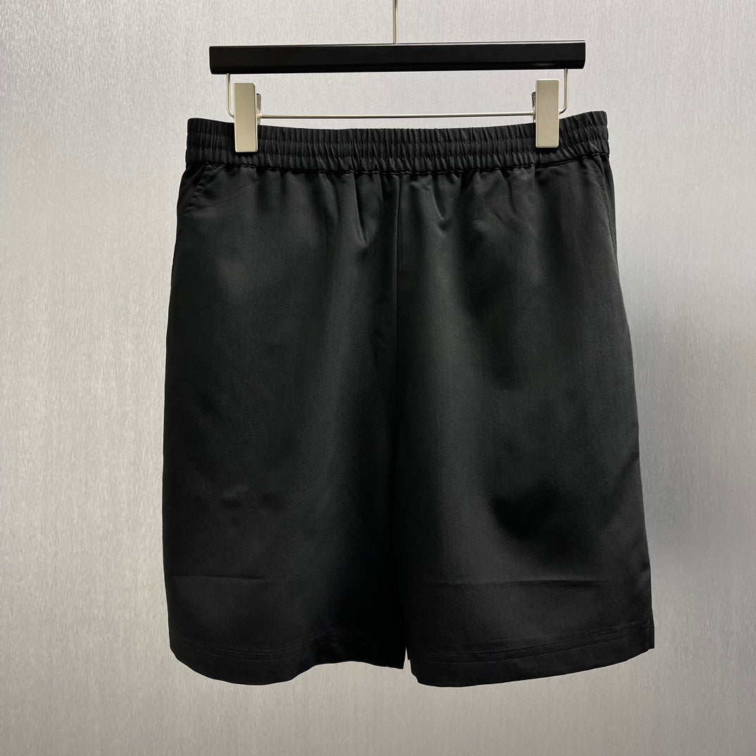 Black satin shorts with elastic waistband and straight hem