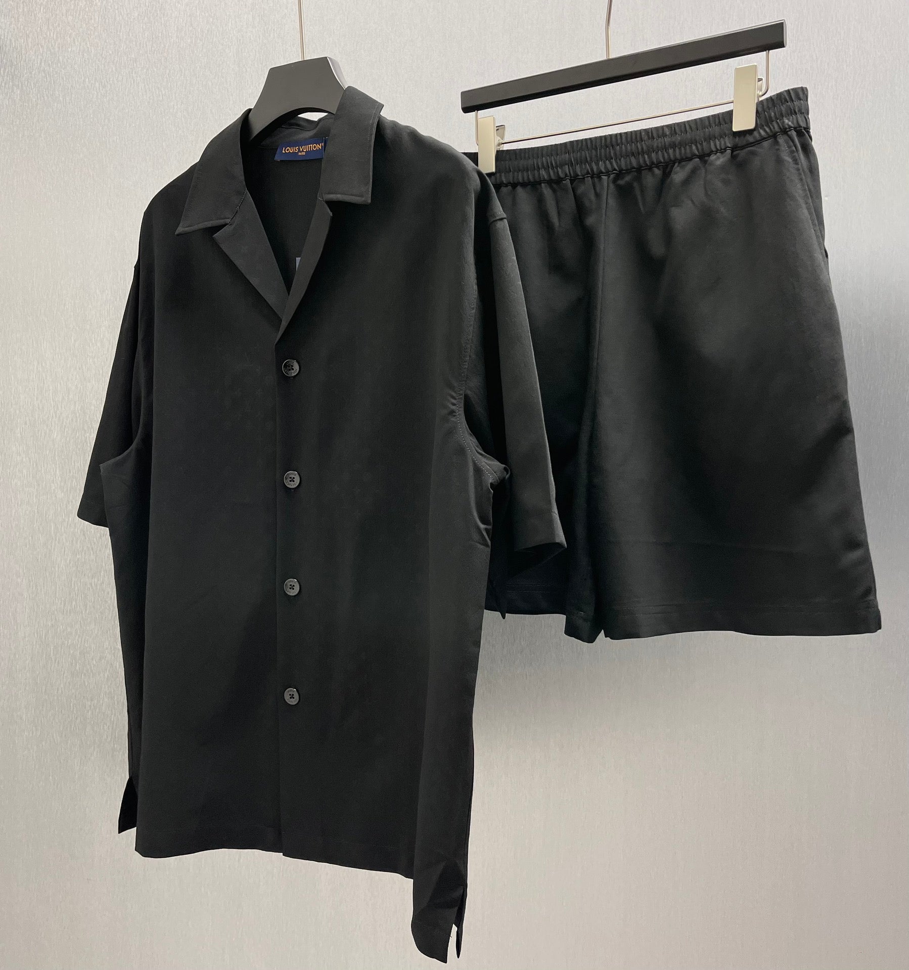 Black elastic-waistband shorts next to a black button-up shirt