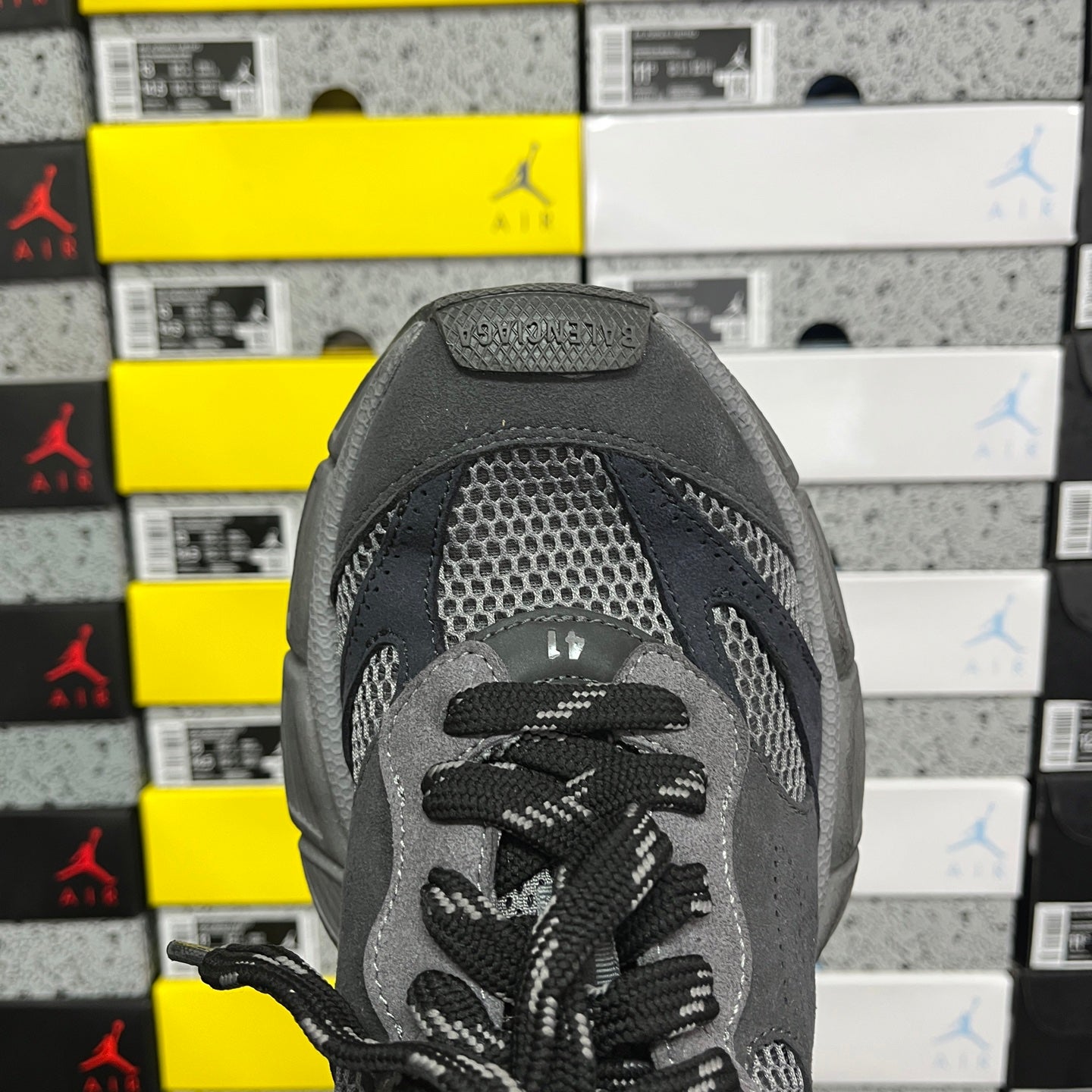 Grey sneaker tongue with lace eyelets and textured mesh upper