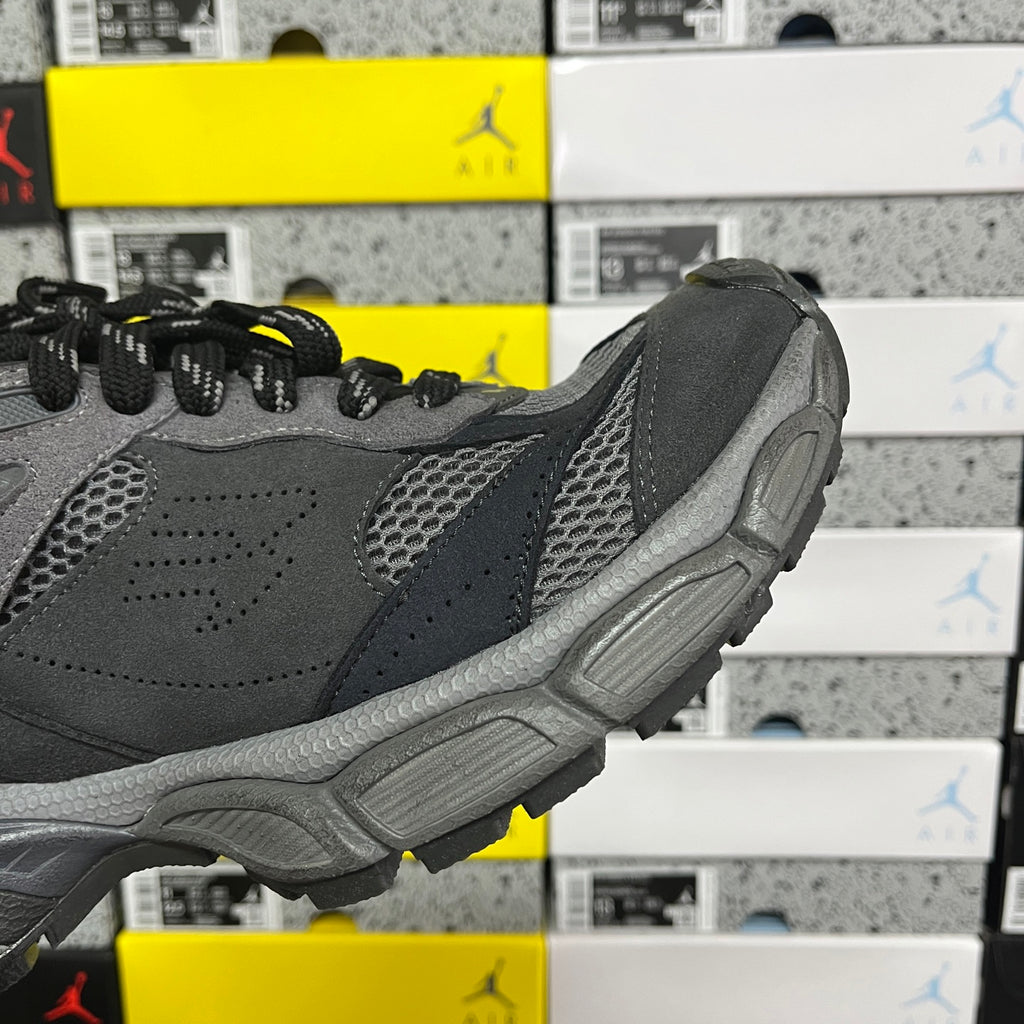 Grey sneaker side profile with perforated paneling and molded rubber heel