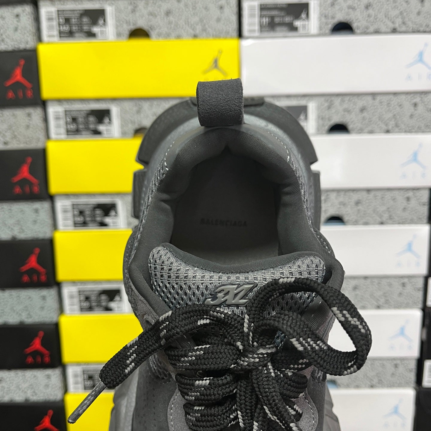 Grey sneaker heel opening with black lace-up closure and mesh lining