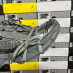 Gray sneaker side profile with lace-up closure and layered textured panels