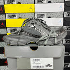 Gray lace-up sneakers with textured upper, panel detailing, and chunky sole