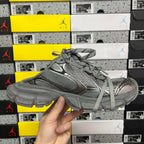Gray lace-up sneakers showing side profile, mesh upper, and chunky midsole