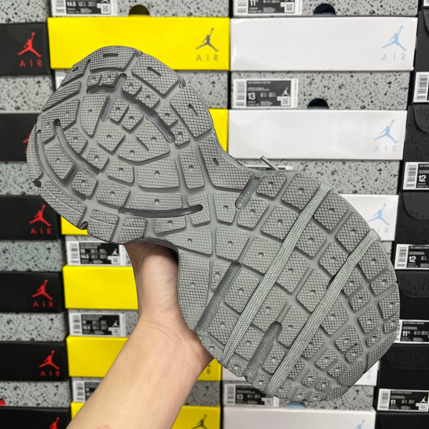 Gray rubber outsole with deep tread pattern and thick strap-like sidewall