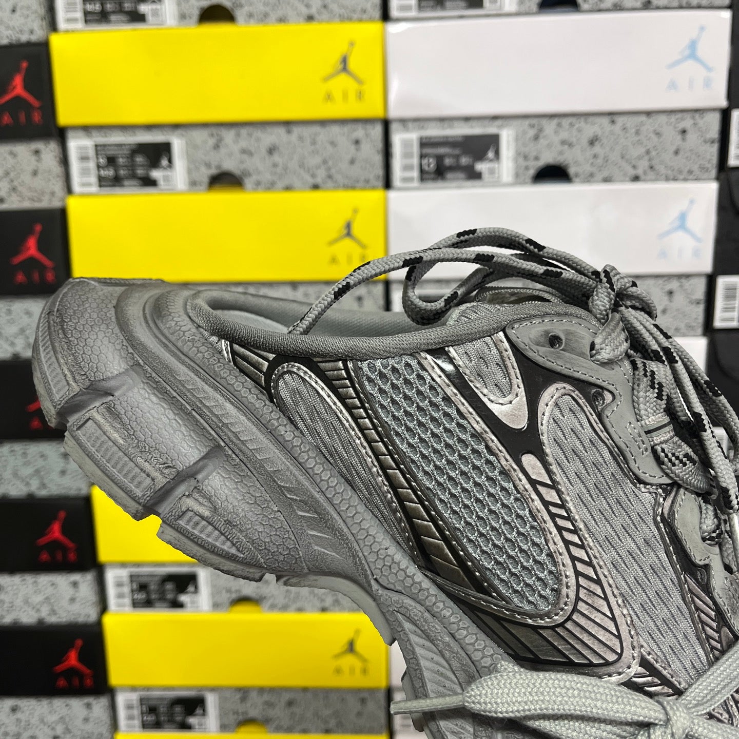 Gray lace-up sneaker quarter view with mesh and suede-like textured panels