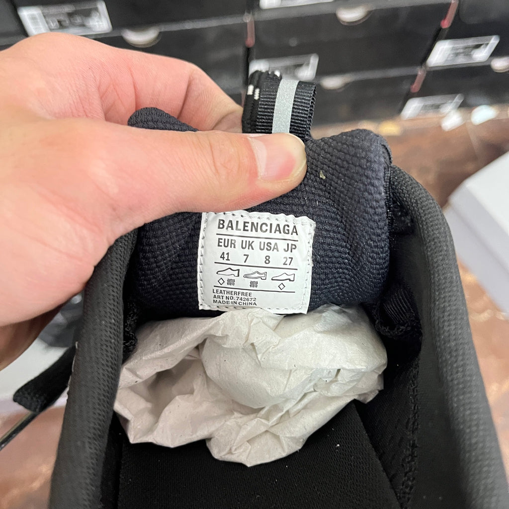 Black sneakers with size label on inner collar and brand text on tag
